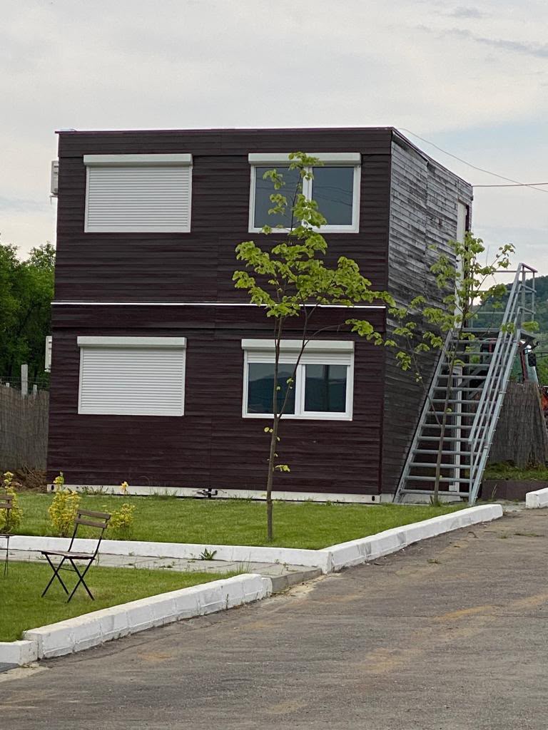 Cameră modernă de tip studio cu ferestre mari și decor contemporan